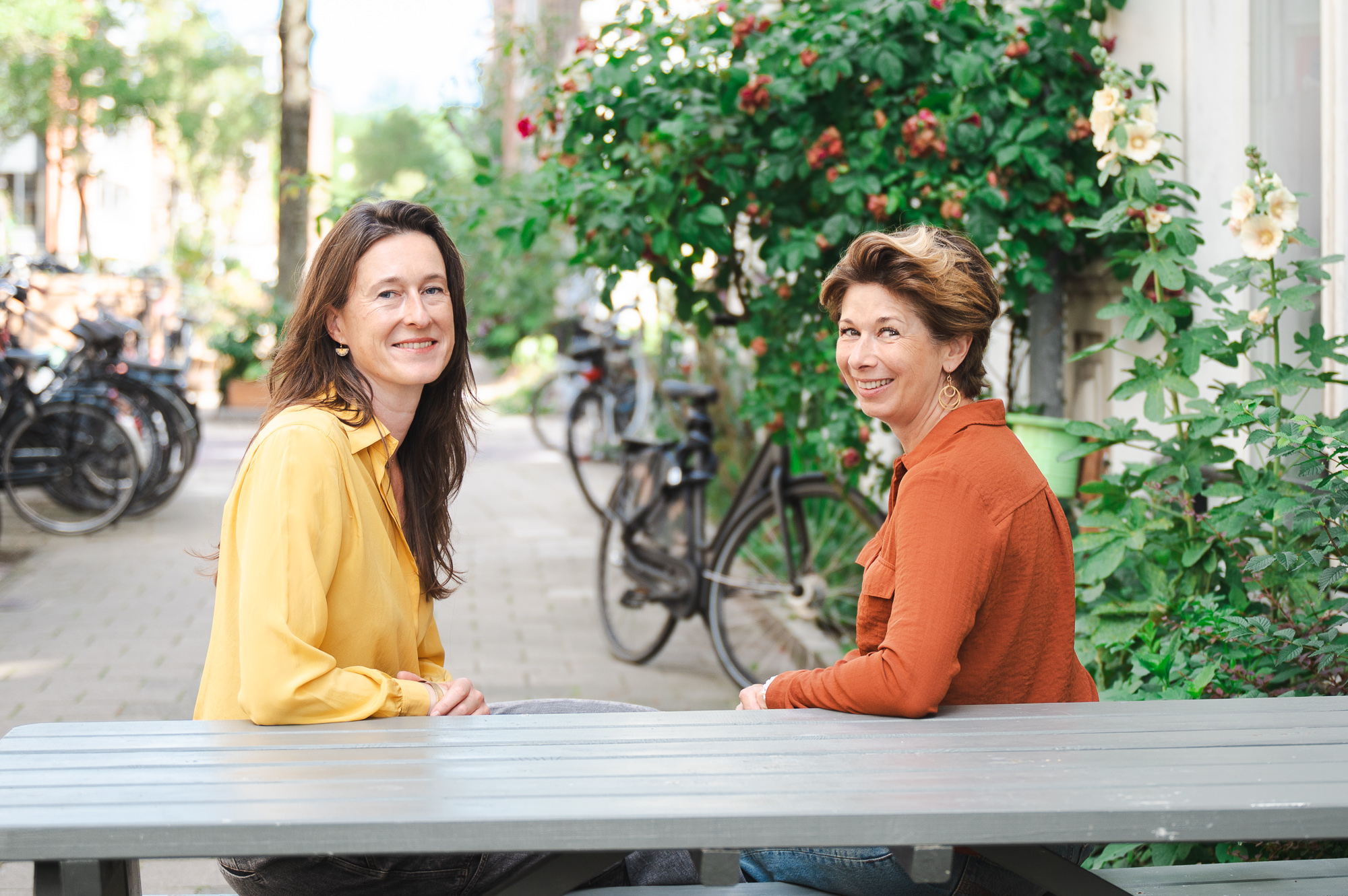 Katja en Ragini aan een picknicktafel in de straat